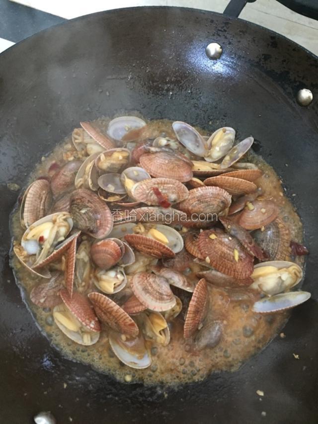 翻炒至花甲全部开了的时候加入料酒和生抽炒匀