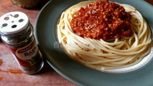 面煮熟捞出控去水份装盘，在意面上敷上番茄肉酱，撒上少许干罗勒碎。