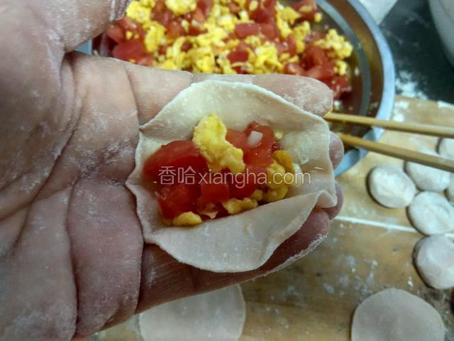 把西红柿鸡蛋馅放入饺子皮里。