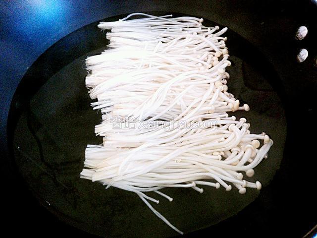 给锅里加入凉水，大火烧开后，把金针菇倒锅里焯一下，焯好后用凉水冰一下，然后放盘子里备用。