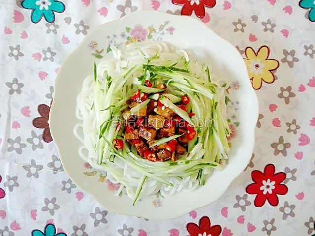 给米粉上放入金针菇，黄瓜，豆干酱，红美人，调入辣椒油，盐，鸡精，味极鲜，然后用筷子搅拌均匀，即可食用。