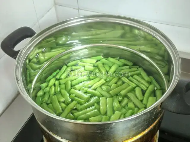 在锅里放一点食用油，把四季豆在锅里焯水，煮熟。