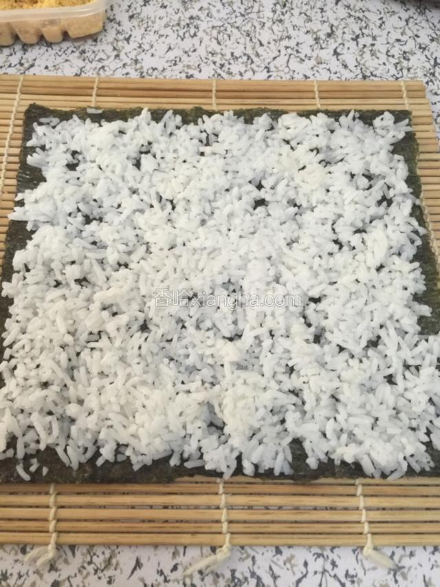 海苔上铺上一层米饭稍加按压