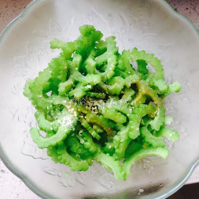 苦瓜沥干水分倒入碗中，加生抽，盐，鸡精调味，用筷子拌匀