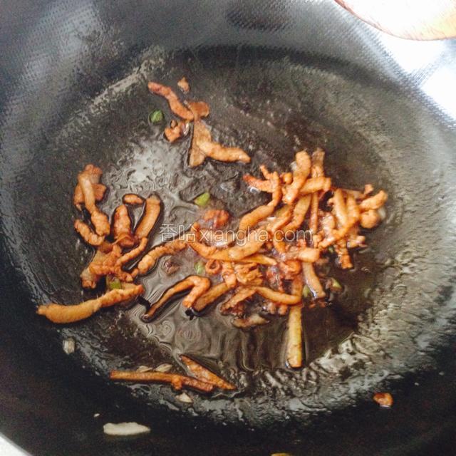 下入猪肉翻炒至变色断生，滴料酒，加老抽生抽糖翻炒
