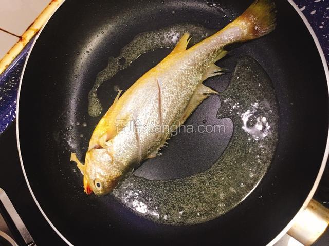 煎锅倒入油烧热，把黄花鱼擦干水份放进去煎