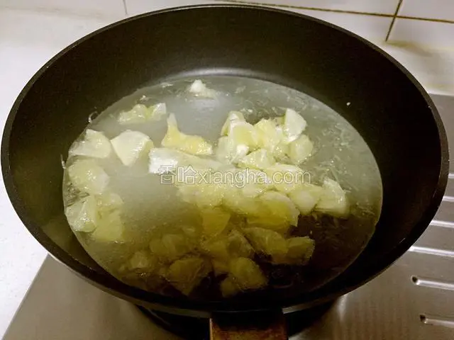 锅擦干后，将腌制过的柠檬果肉连同腌渍出的糖水一起倒入锅里。