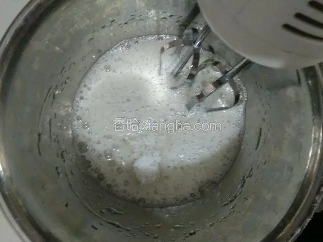 用打蛋器打出鱼眼泡泡，放入一半白糖，继续打