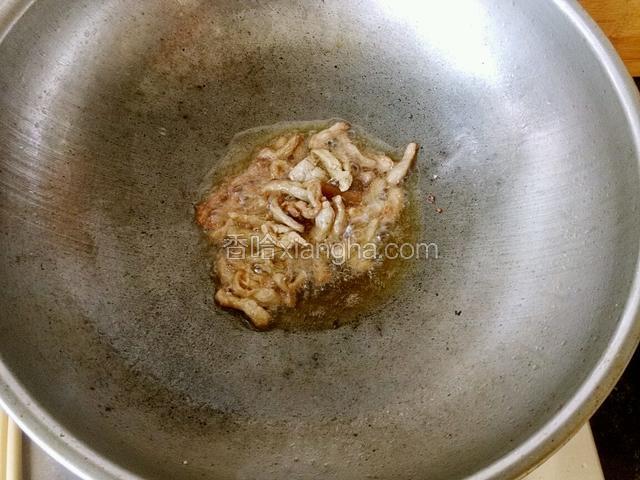 锅中下油下肉丝和姜翻炒至肉丝变白