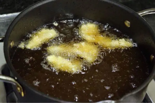 用小点的油炸锅，放多一些的油。烧至五成热，中小火炸鱼柳至浮上油面，迅速捞出。