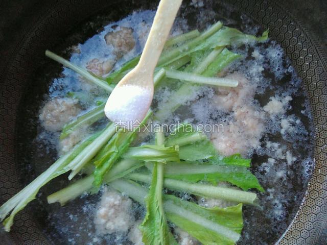 加入白菜杆。再加一勺食盐。继续煮。