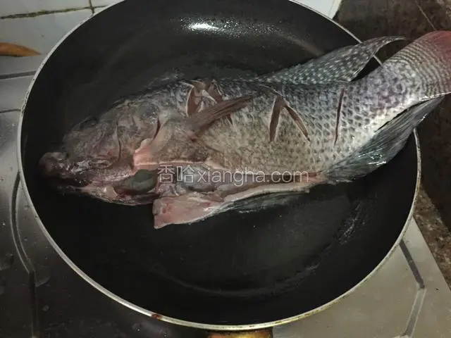 平底锅倒入适量的油烧至六七成热时放入鱼，小火炸至表面金黄色