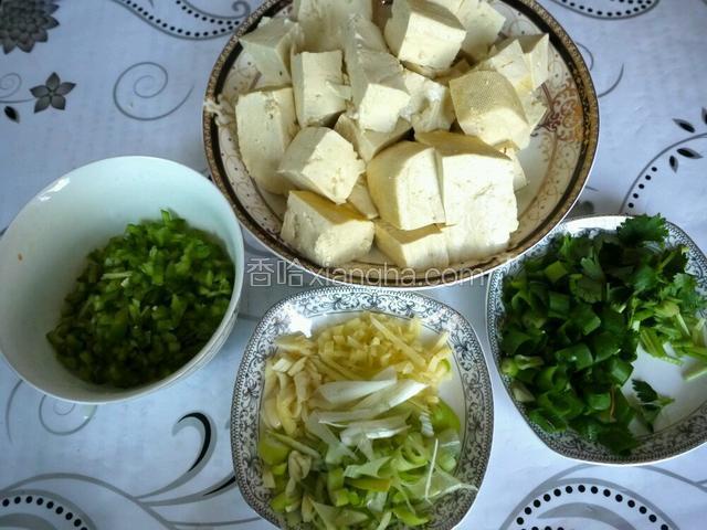 北豆腐切小方块，葱姜蒜、尖椒切碎，香菜、香葱切末备用。