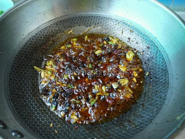 放入十三香、豆豉炒出红油后，倒入大豆酱翻炒。