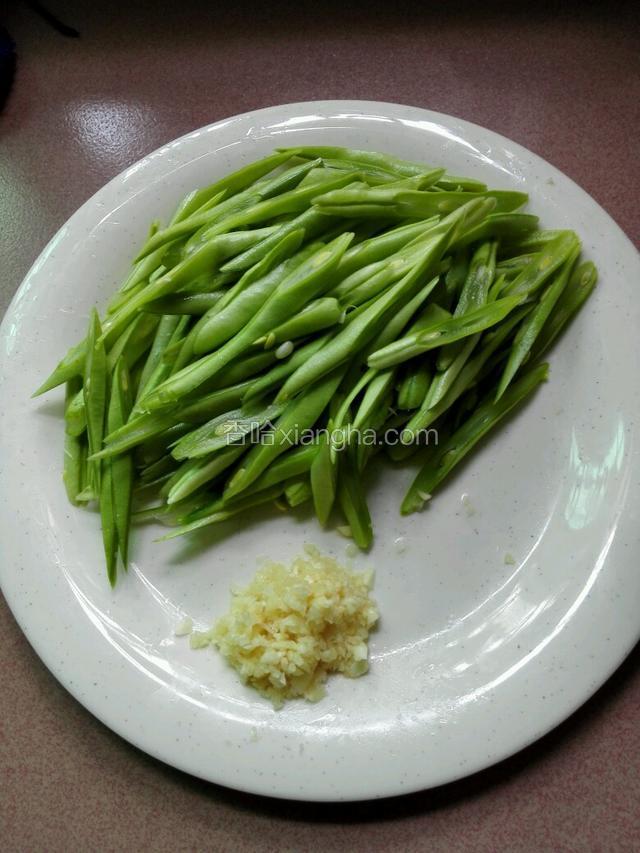 四季豆斜刀切片，蒜头剁末。
