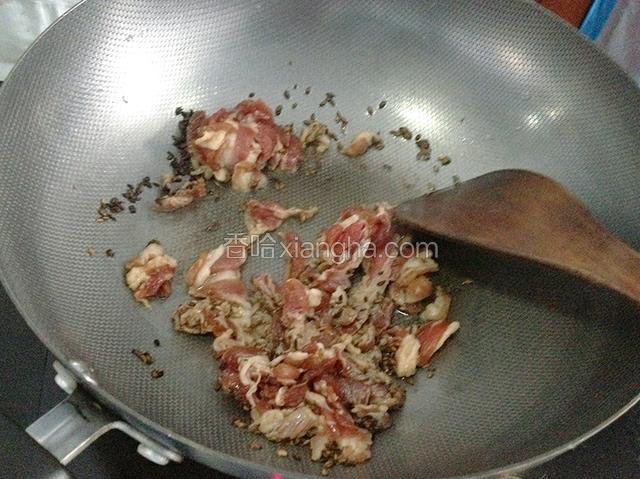 倒入腌制的肉片，用锅铲迅速划散。