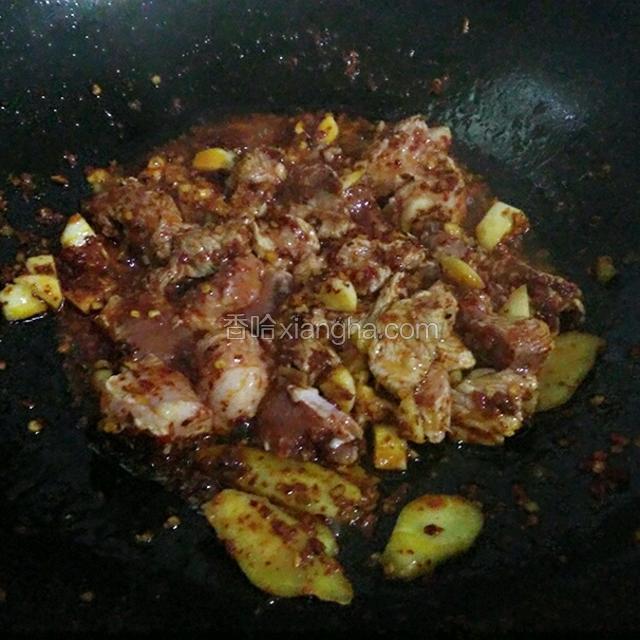 锅中热油倒入姜蒜爆香，加一勺辣椒粉炒出红油，再将猪肉倒入快速翻炒一下，加一勺老抽。