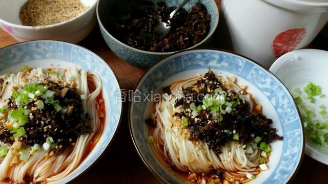 面熟后捞出，折叠两次码入碗底，在面上依次码上肉臊、花生碎、白芝麻、葱花。