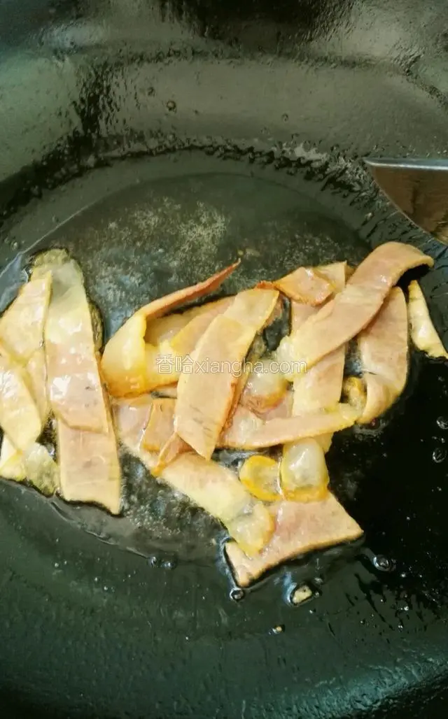 炒锅内放油，下入火腿小火炒香