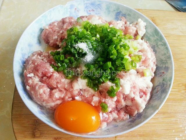 在肉末中加入鸭蛋，葱花，盐和料酒