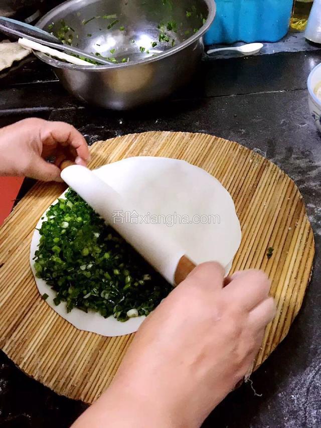 用擀面杖把另一张饼皮盖上，周边压好