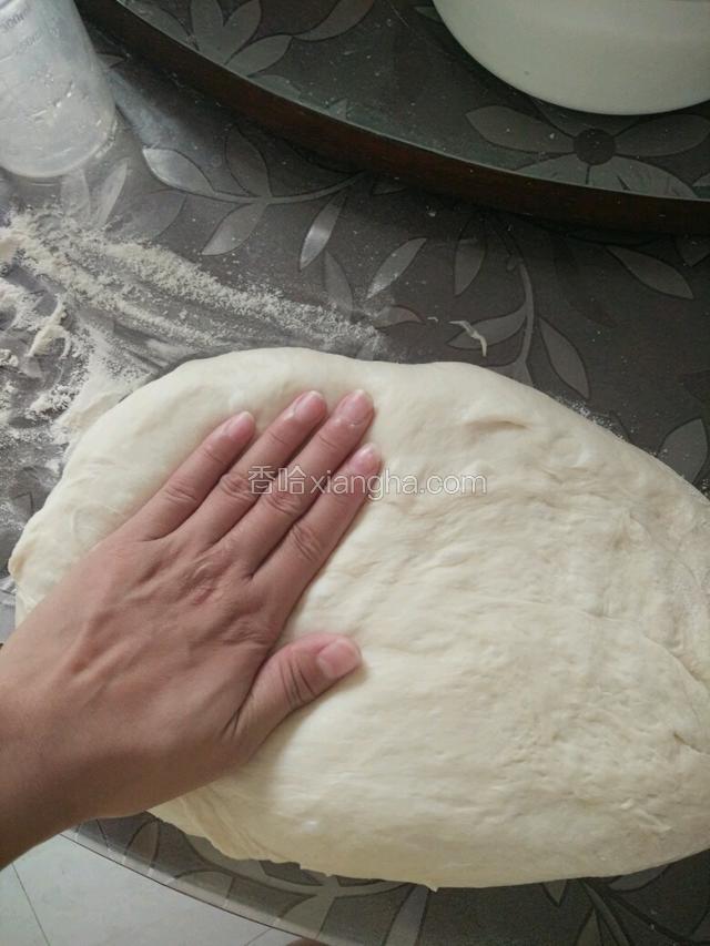 将面团取出，桌上洒点面粉，把面团的空气排出，用按压的方式就可以了，