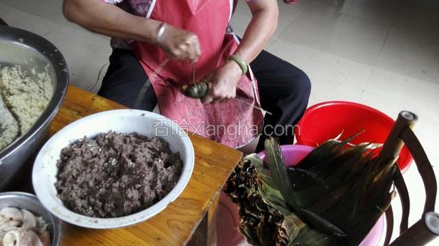 用拿水草留个长尾巴，另一边这绕着粽子打圈，绕到留打个结！