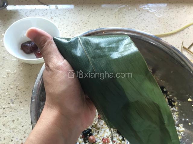 上面的叶子往下折，抽出大拇指，用左手压住盖过来叶子的左侧。