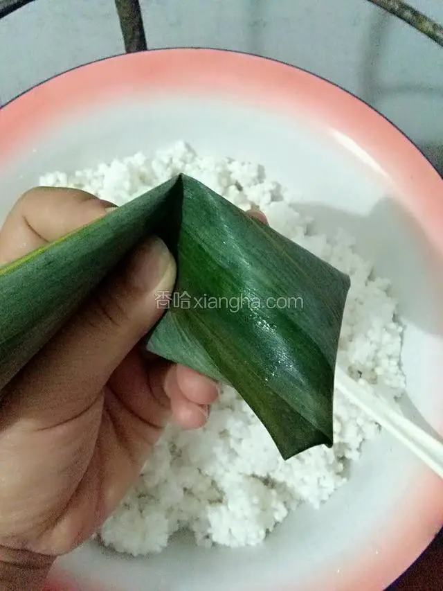 将捏紧的粽叶对折
