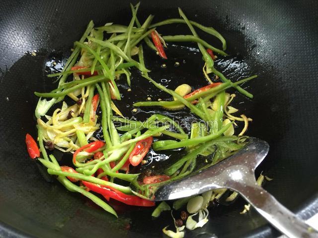 继续下入青椒丝和小米辣翻炒出香味。