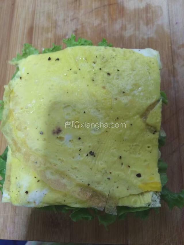 在煎好的土司上摆上生菜，蛋饼。