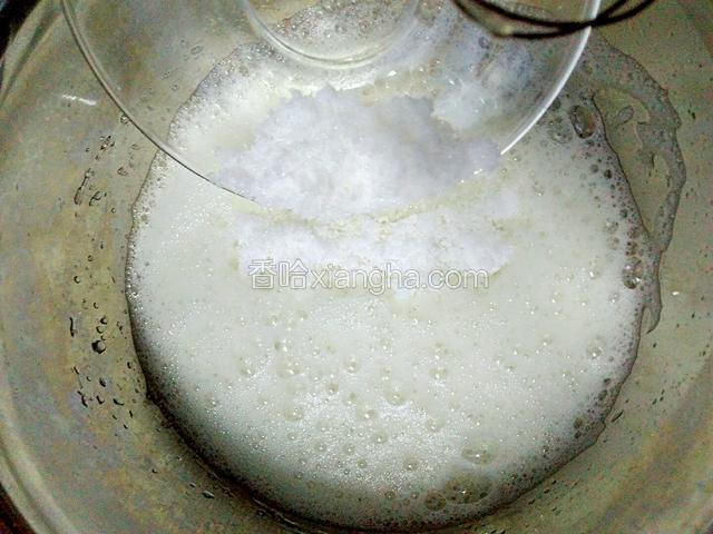 等打至泡泡变白变细腻以后，再加入剩下的30g白糖。继续低速打发。