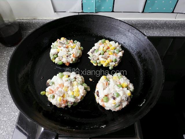 用勺舀满一勺食材，分别放入预热平底锅压成饼状，小火慢慢烙制。