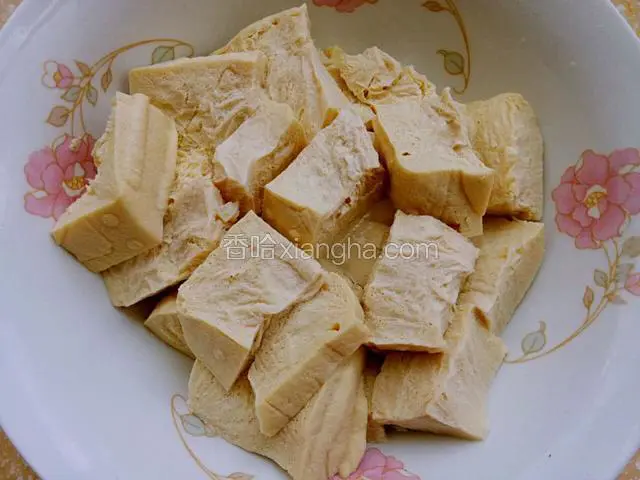 冻豆腐化开冲洗干净，挤干水分放在盘里。