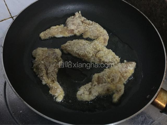 平底锅倒入适量的油烧至六七成热后放入鸡胸肉，小火煎至金黄色