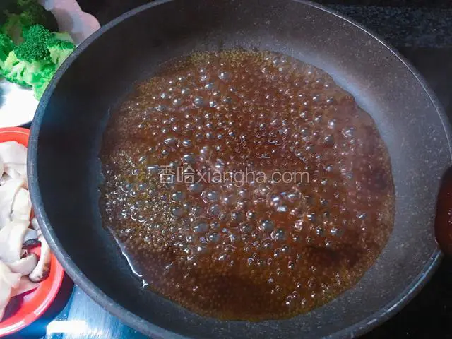 炒锅里倒入适量的蚝油，加入清水和糖搅匀，大火烧开