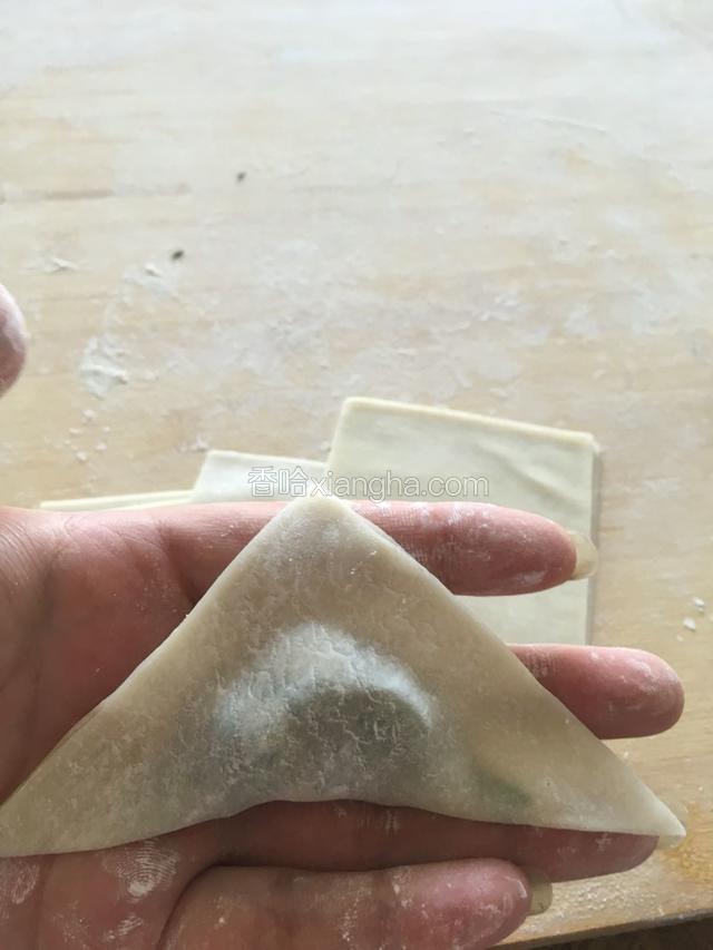 两角对折，捏成三角形，把边捏紧