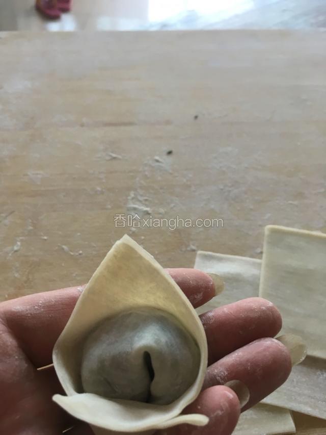 将两个角捏在一起，漂亮的官帽馄饨就做好了