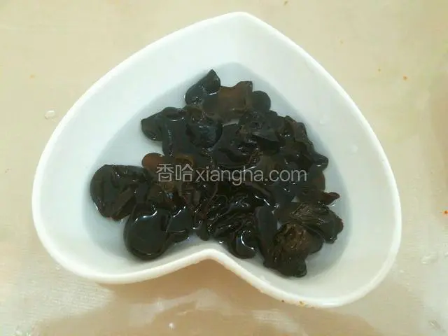 将干木耳用温水泡开。