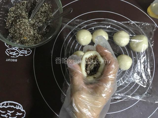 放入糖糕馅儿，用虎口向中间挤最后捏紧，依次完成每一个；