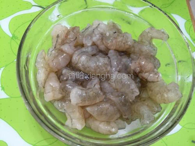 然后去剥去虾壳取出虾线，切成两半，用盐和料酒抓匀盖上保鲜膜放入冰箱冷藏十五分钟左右