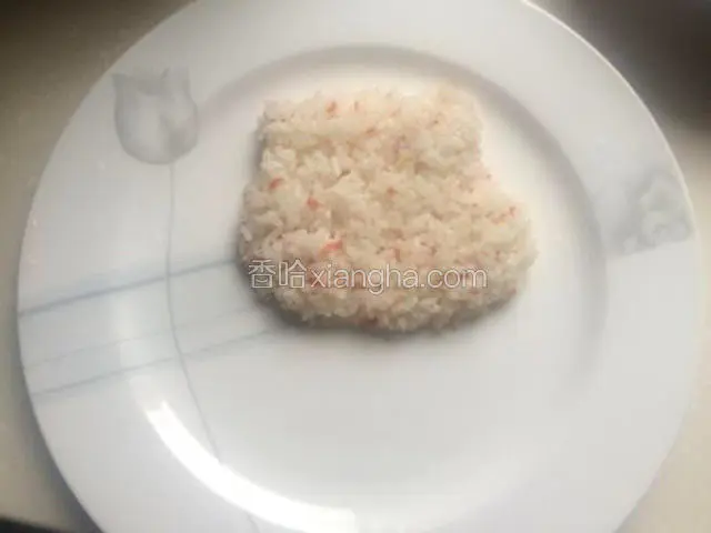 取适量炒饭在盘子上方压出猪头形状