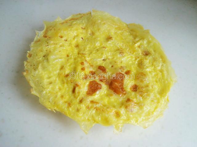 一个鸡蛋饼就摊好出锅了，继续把第二个鸡蛋打入碗里，同样朝着一个方向搅散，然后摊第二个鸡蛋饼。
注：稍微晾凉一些再切。