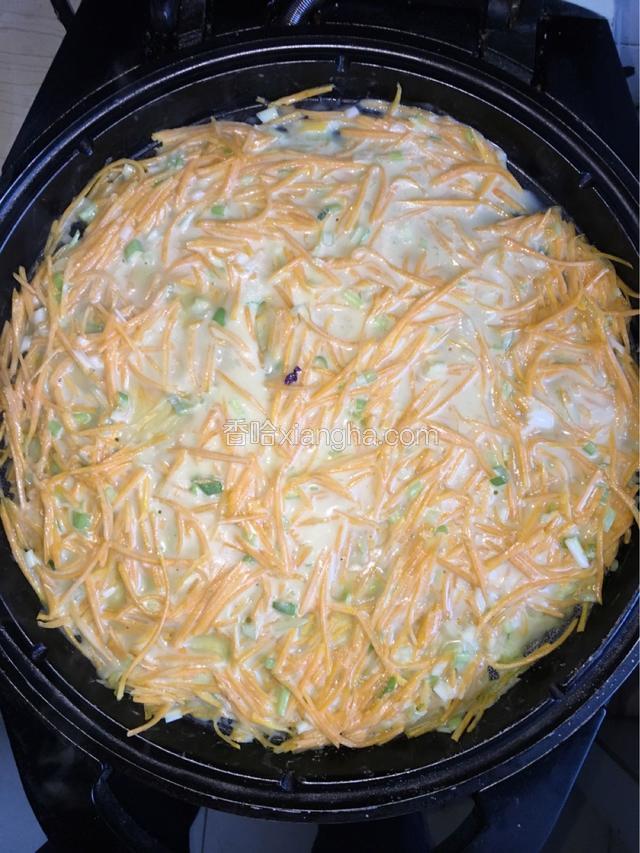 加热电饼档后，涂抹少量油，将调好的面糊倒入电饼档，均匀摊开。
