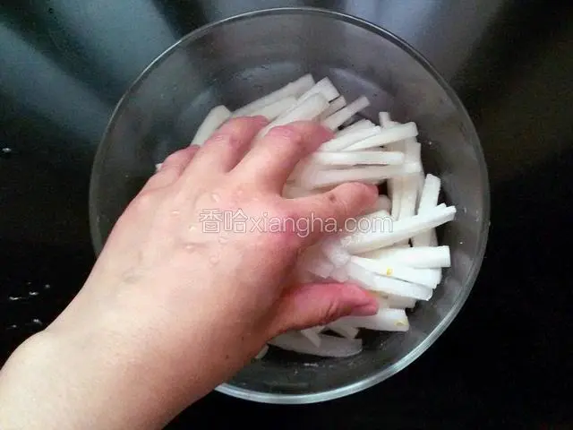 用手抓萝卜条，使萝卜条和盐充分融合。