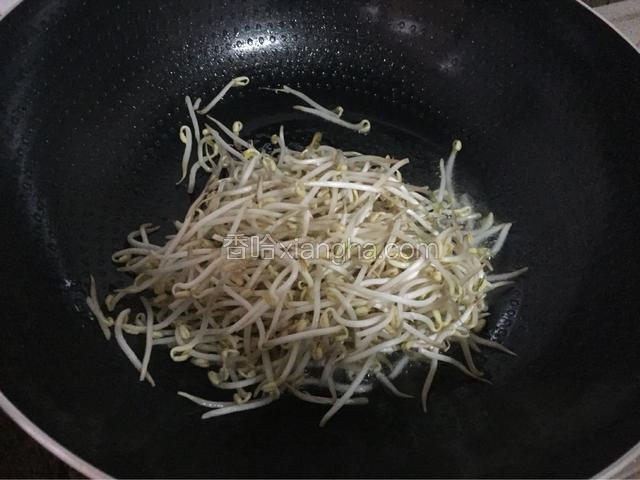 锅中倒入适量的油烧热后放入绿豆芽，大火翻炒片刻