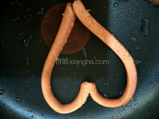 热油锅下火腿肠慢火煎软，然后翻转两边往中间靠拢用牙签串起来成爱心形状