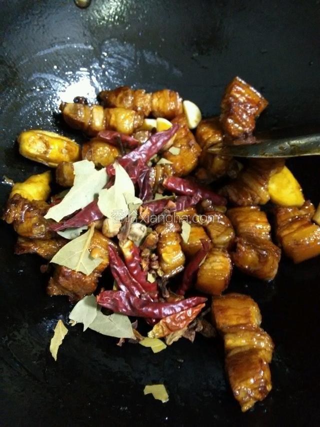 放入五花肉进去炒，炒至五花肉成金黄色，放入蒜，姜，大料。