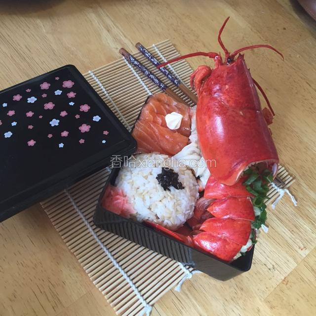 摆盘。将龙虾整只摆入饭盒，将米饭用保鲜膜抓成球，放入饭盒。生鱼片铺在饭上。海苔装饰洒在饭上，生鱼片上挤上蛋黄酱。完成