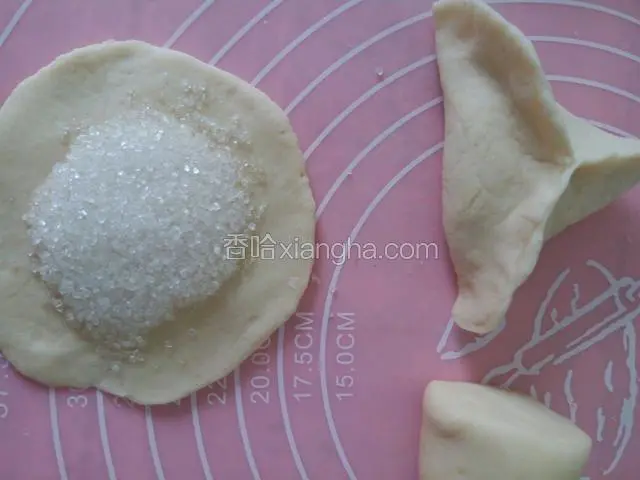 中间放些白糖，用大拇指和食指捏成三角形状，一个三角糖包就做好了。